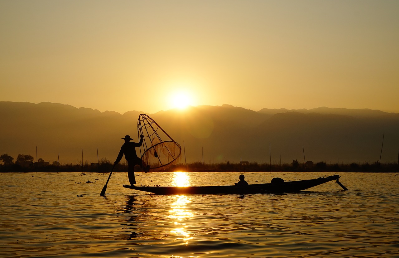 Pêcheur traditionnel qui pagaye à une jambe sur le lac Inle, en Birmanie, Myanmar, Asie